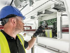 Technician working on a window automation control panel during commissioning