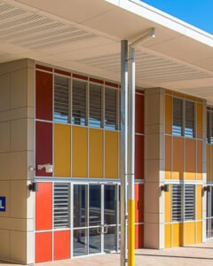 Louvre windows in a red and yellow facade at Excelsior Public School